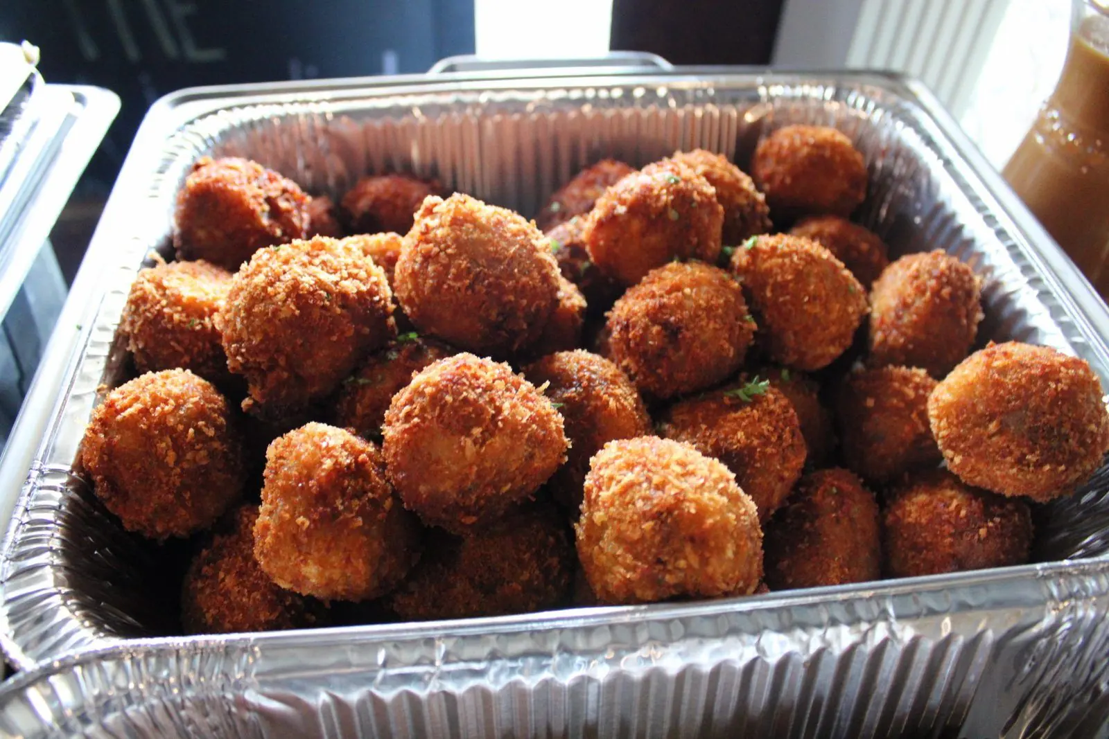 A full pan of golden fried boudin balls