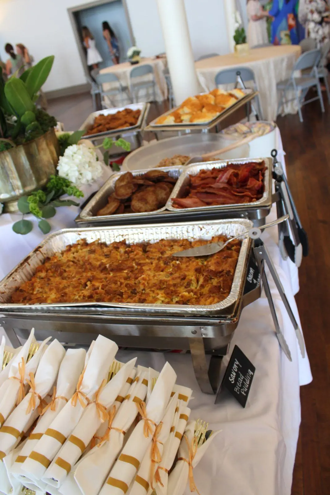 Savory bread pudding, bacon, and sausage on a catered buffet
