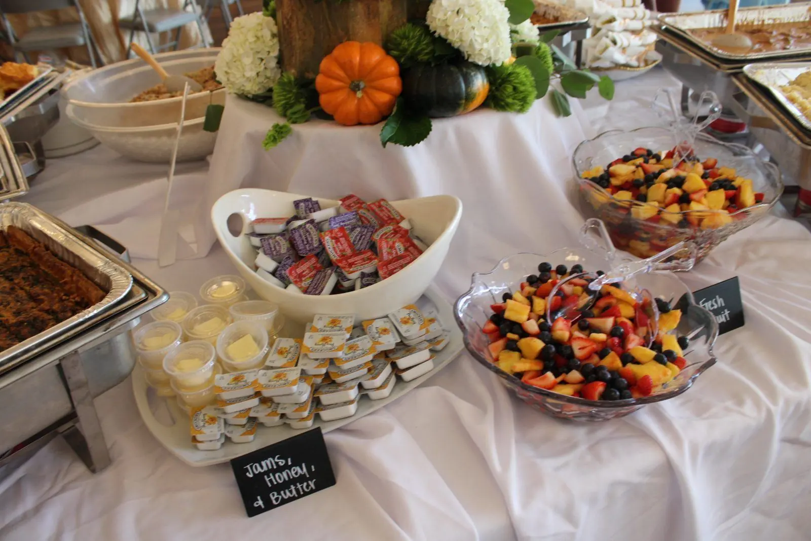 Fresh fruit bowls with jams, honey, and butter