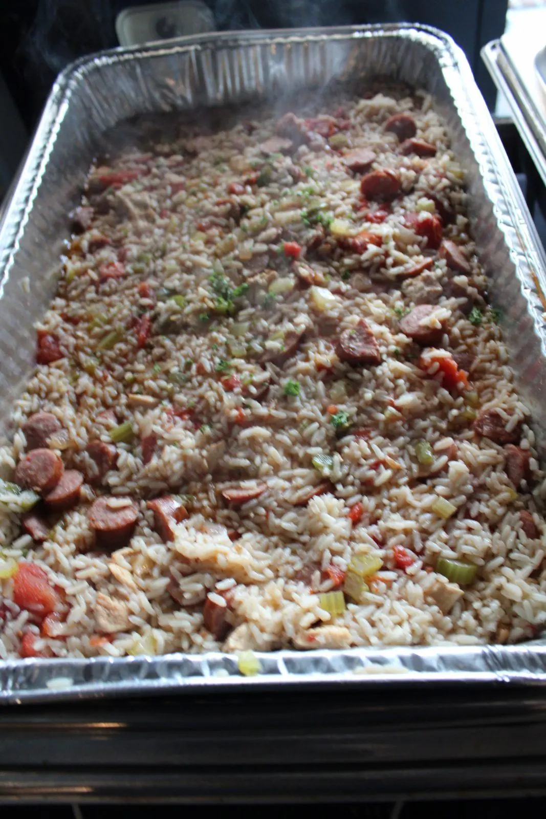 A steaming pan of jambalaya with sausage and chicken