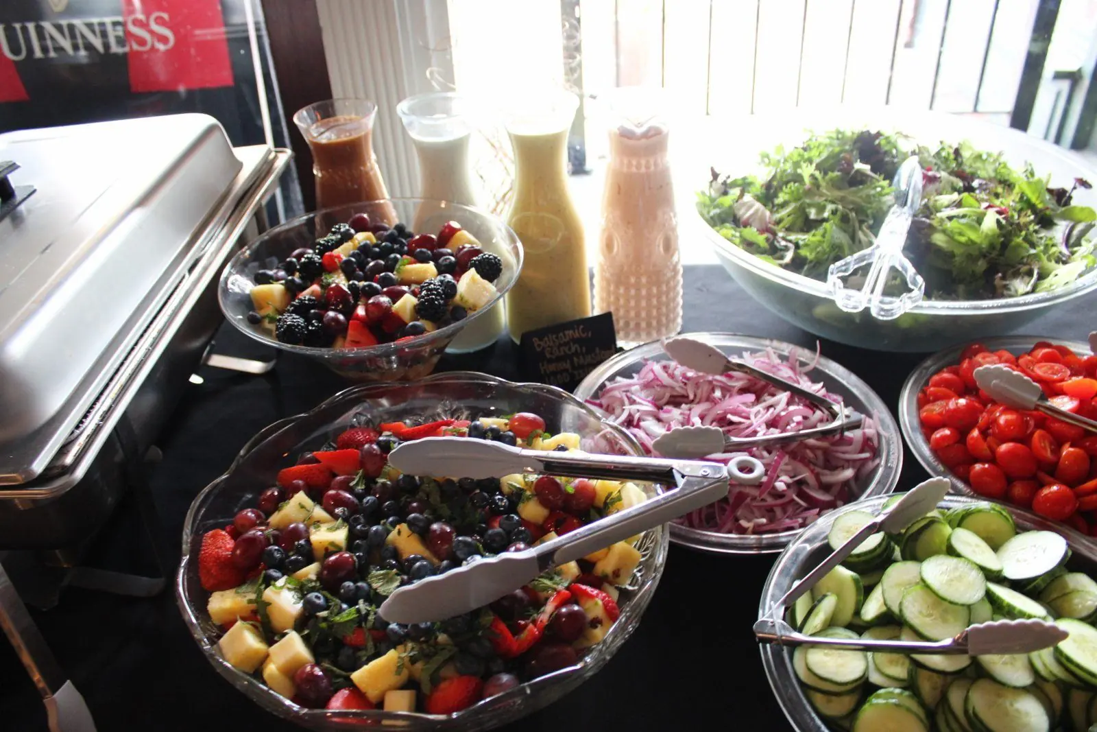 Salad bar with greens, toppings, house dressings, and fresh fruit