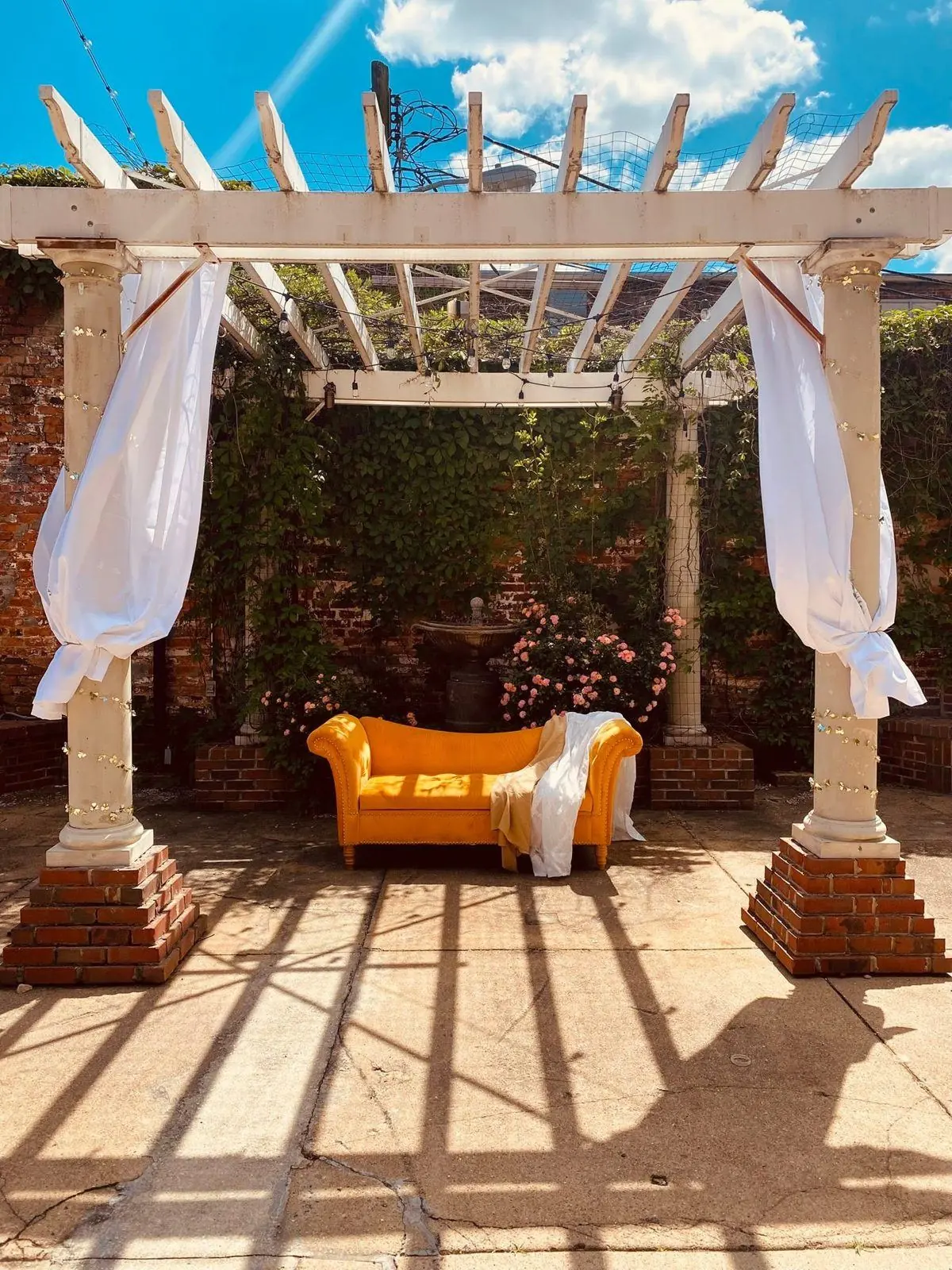 The courtyard pergola with a velvet settee under string lights
