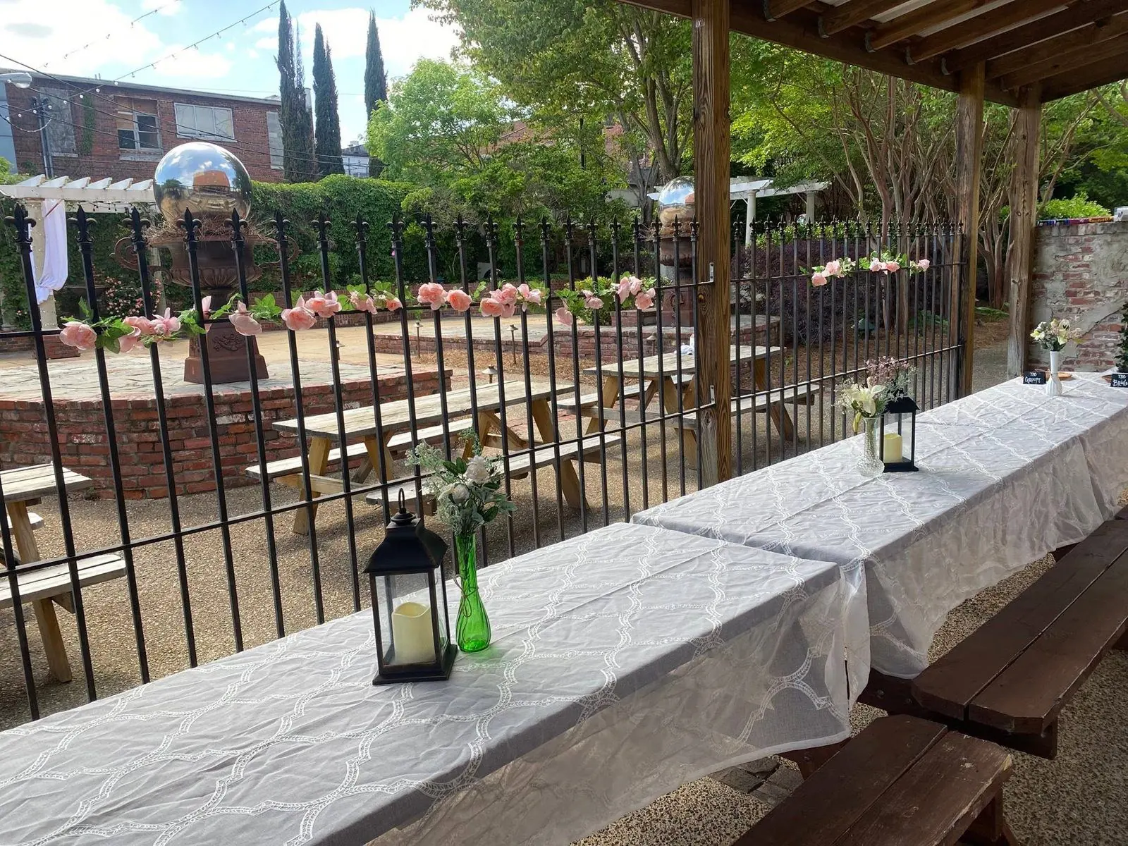 Courtyard tables set with lanterns and flowers for a wedding party