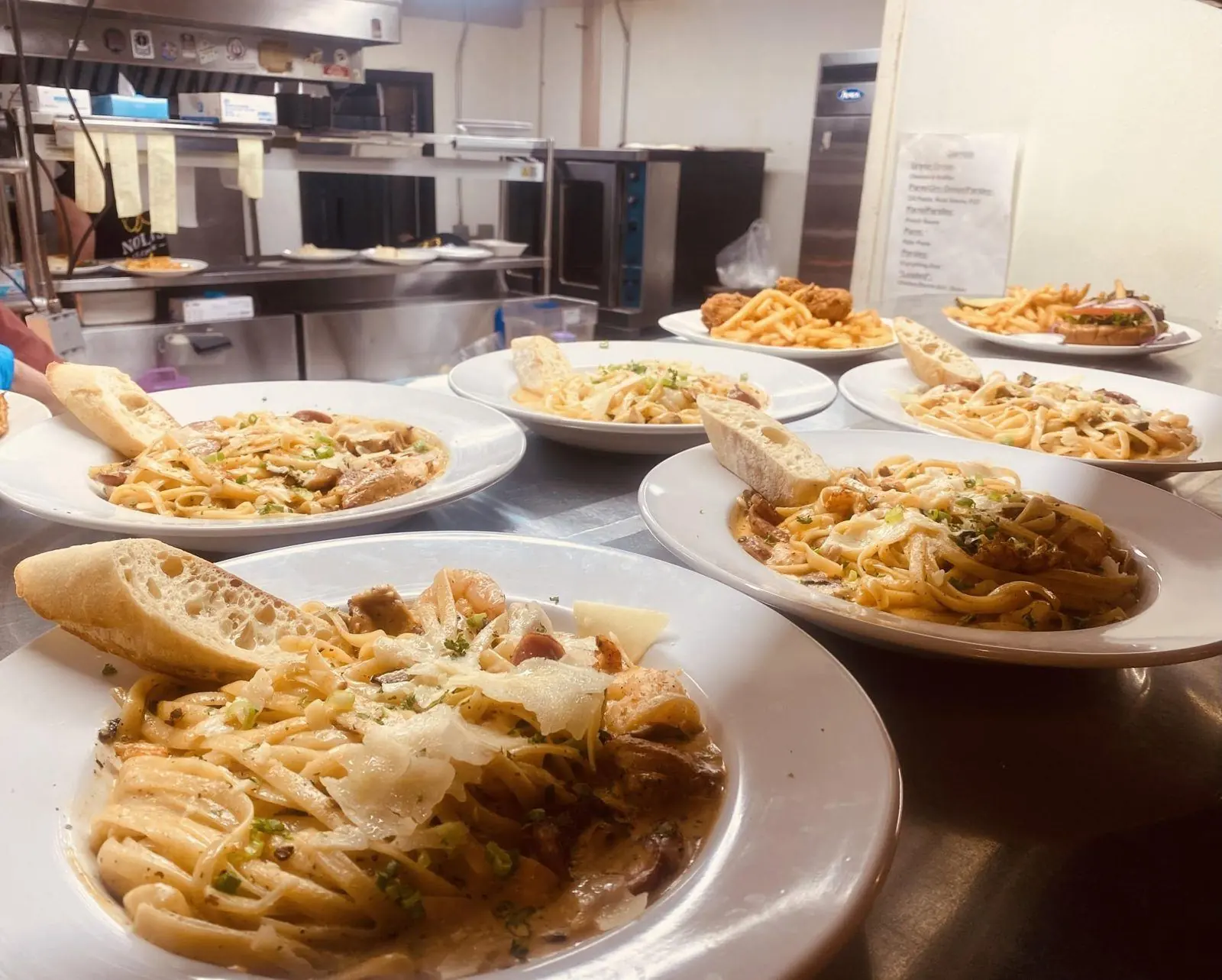 Plates of Rougaroux pasta lined up on the kitchen pass