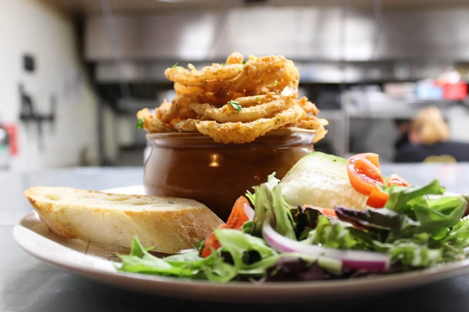 Shepherd's pie crowned with crispy onions, served with salad and bread