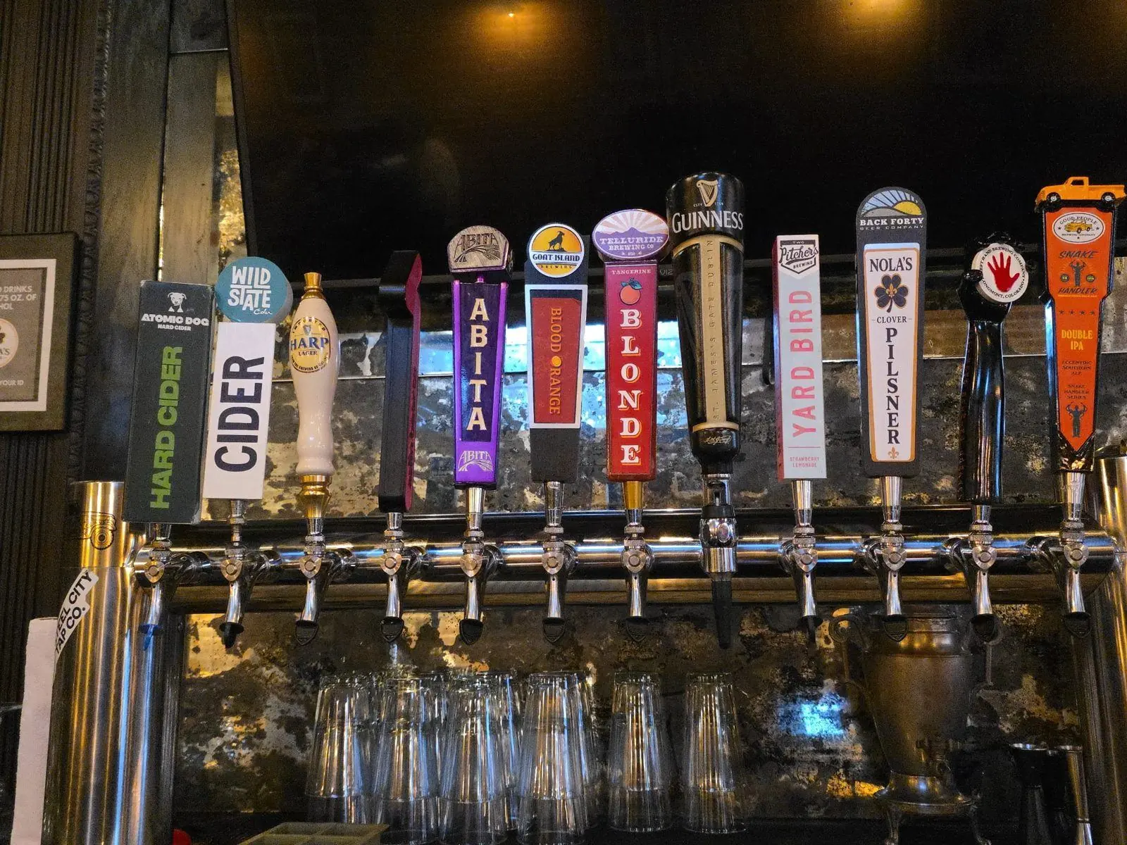 Twelve beer taps behind the Nola's Clover bar, including NOLA's Clover Pilsner from Back Forty, Guinness, Harp Lager, Abita, and hard ciders